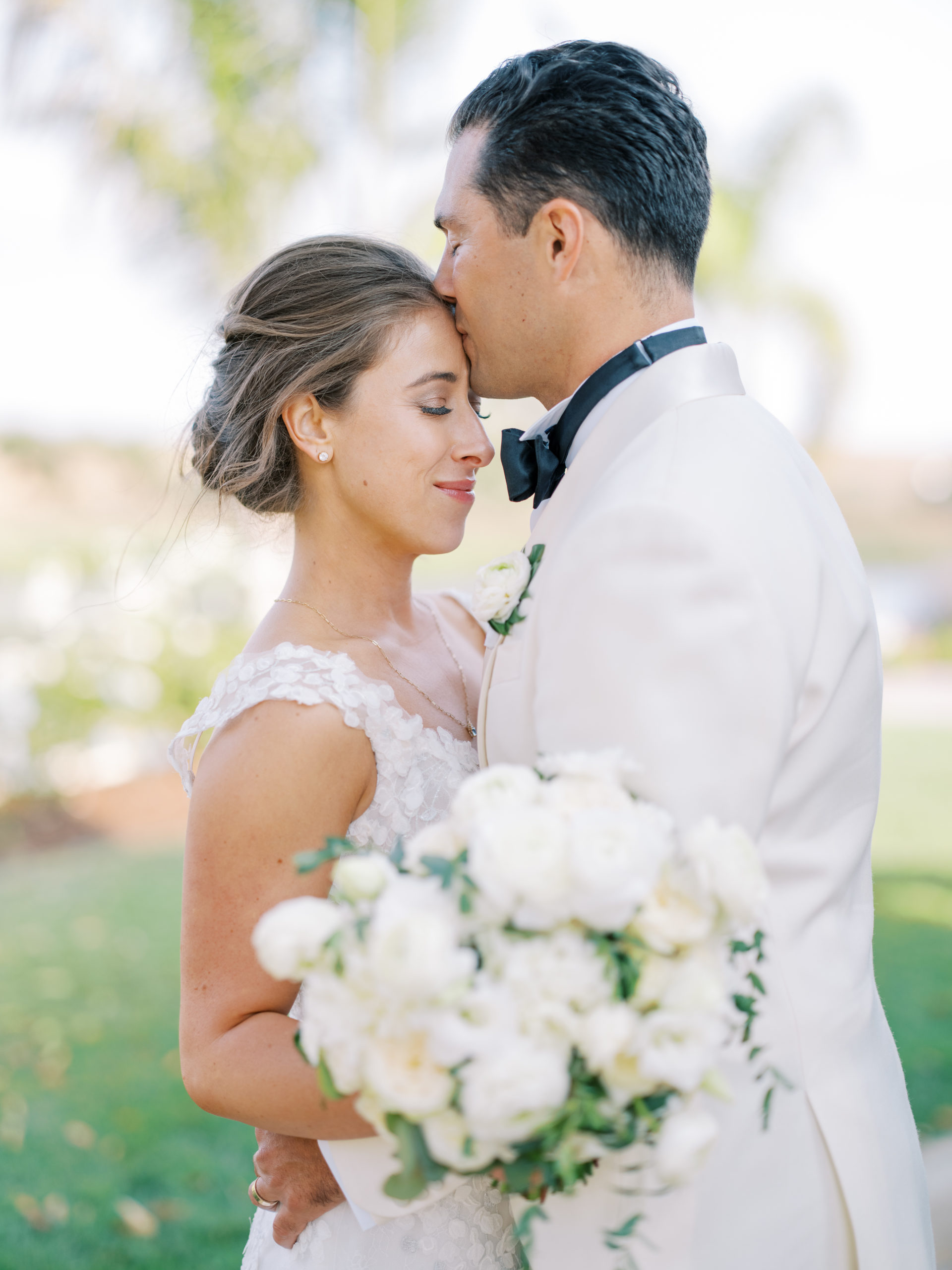 La Lomita Ranch wedding bride is kissed on forehead by the groom
