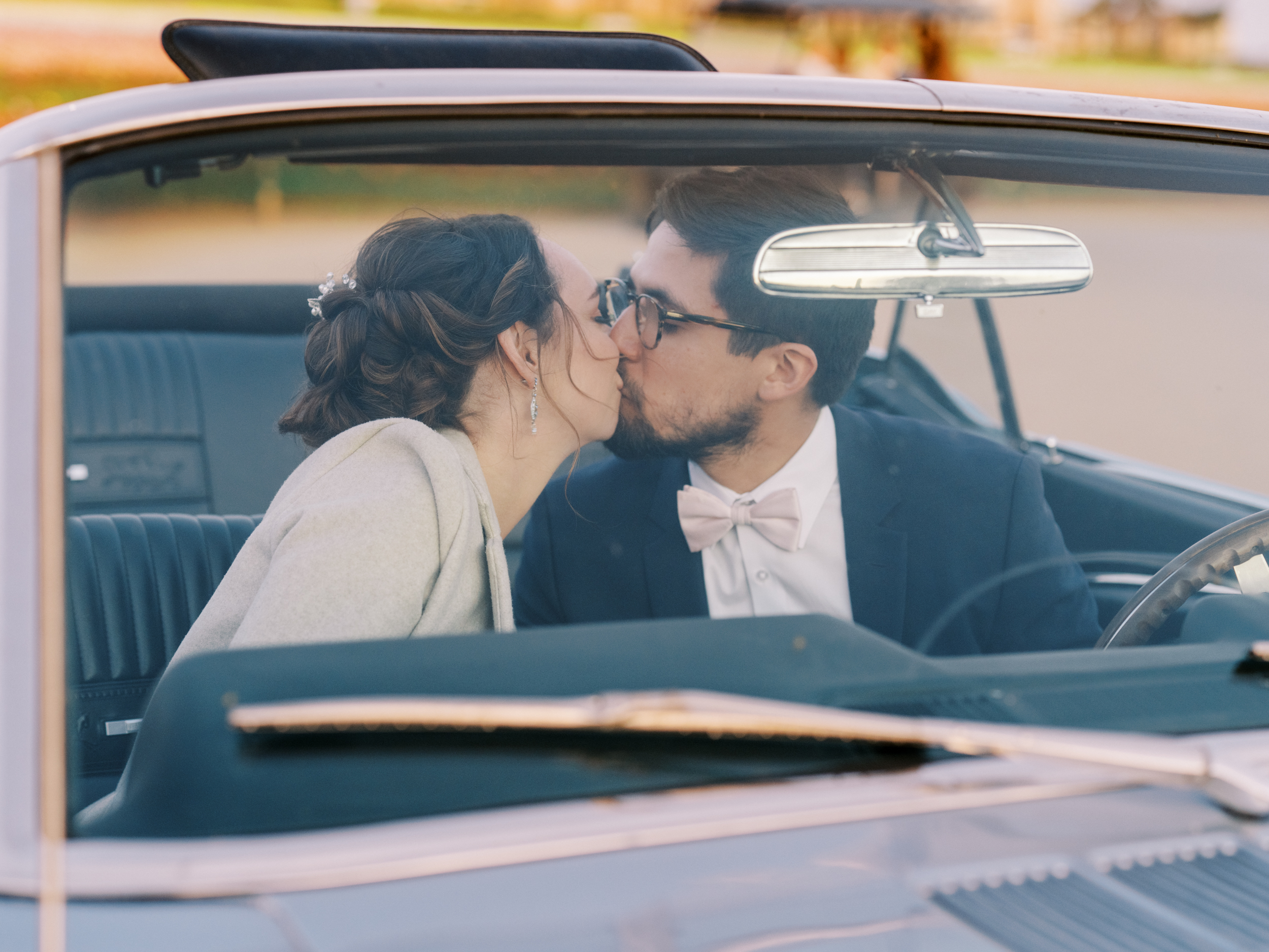 bride and groom in classic getaway car