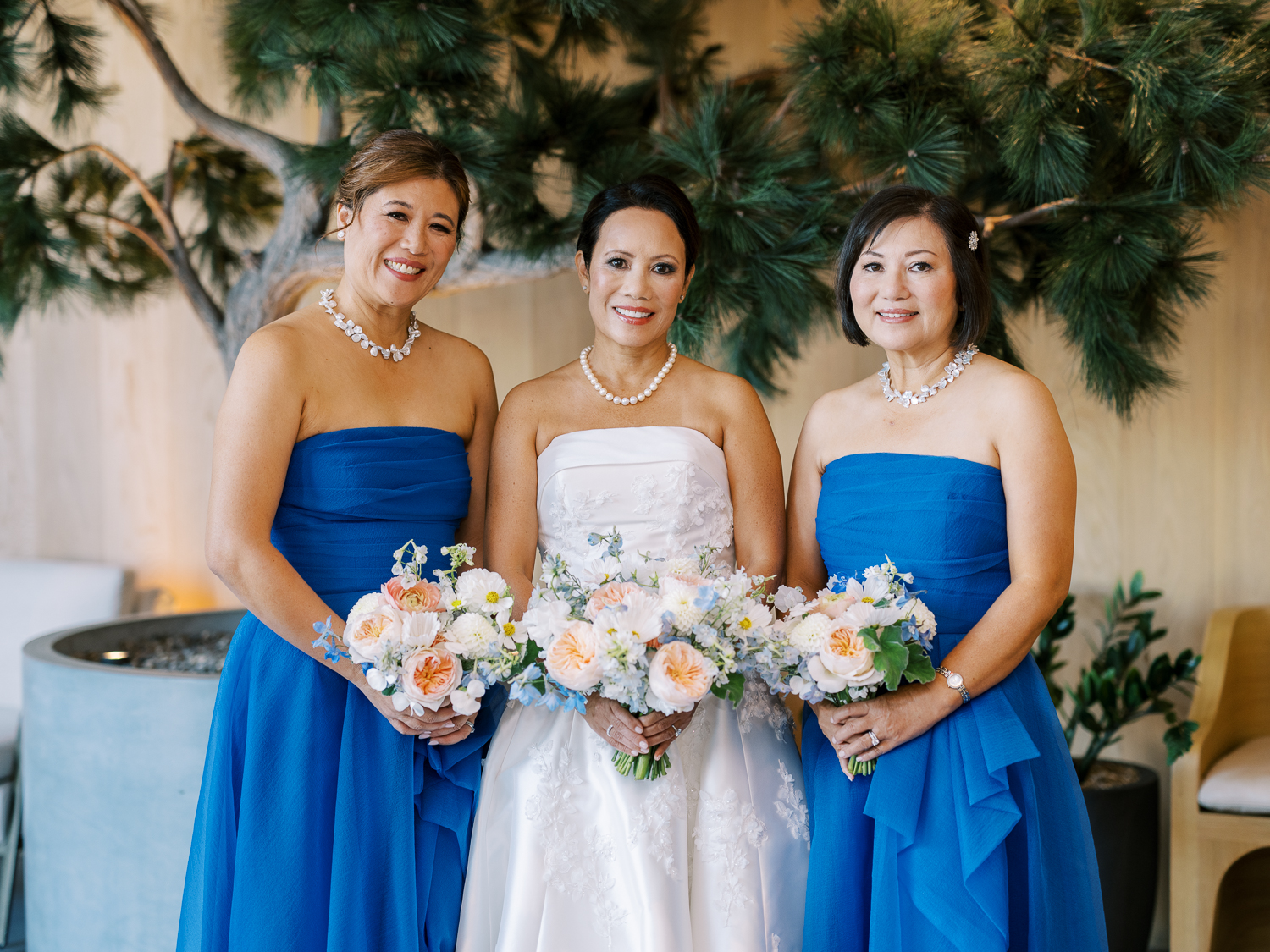 The bride and matrons of honor take portraits at Alila Marea Beach Resort