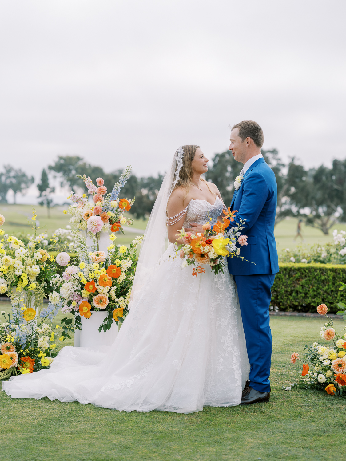 The bride and groom share a moment at their ceremony florals at The Lodge at Torrey Pines