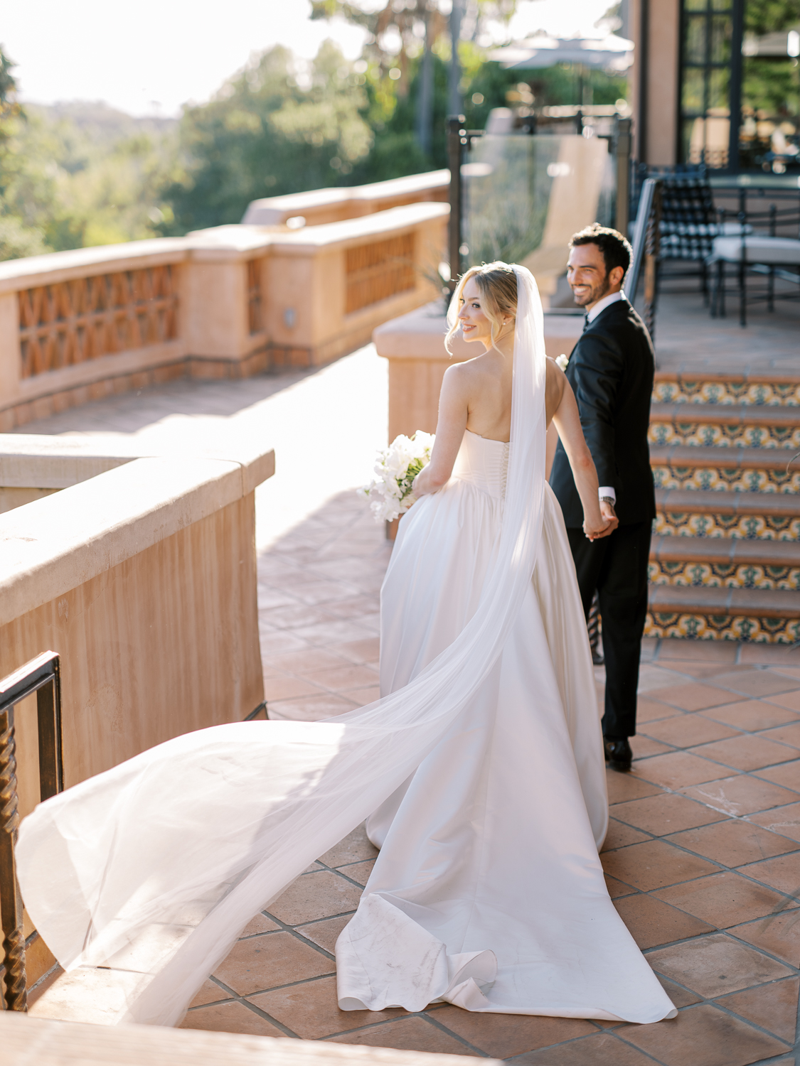 The bride's veil catches the wind at Rancho Valencia summer wedding