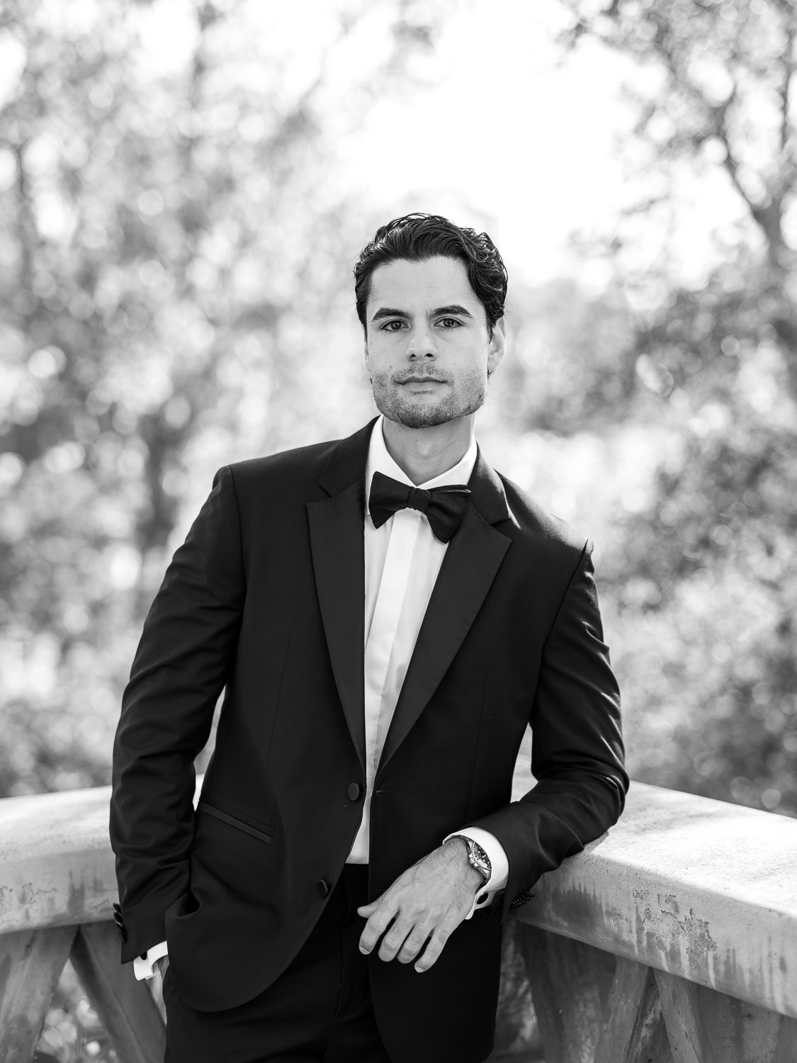 groom wearing black tuxedo outside rancho valencia wine cave